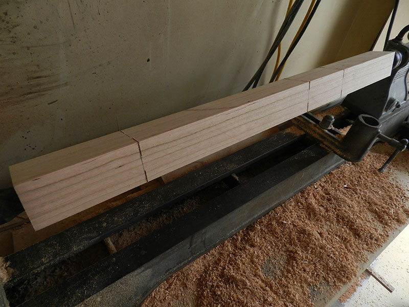 1-3/4 inch x 1-3/4 inch counter stool leg secured between lathe centers with scribed and cut sections to be turned and gouged