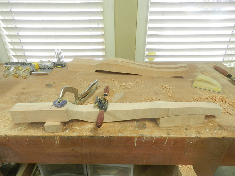The bench top clamping arrangement for shaping the cabriole leg used to build the bedside table frame with cut outs from the band saw sectioning process