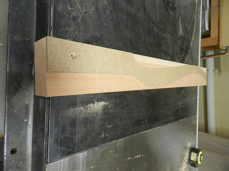The template made from hardboard for marking the cabriole shape on the work piece used to build the bedside table leg