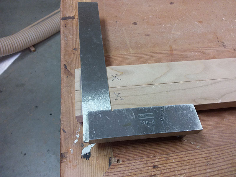 Marking a line with set square on lower side rail to position Dowelmax for drilling