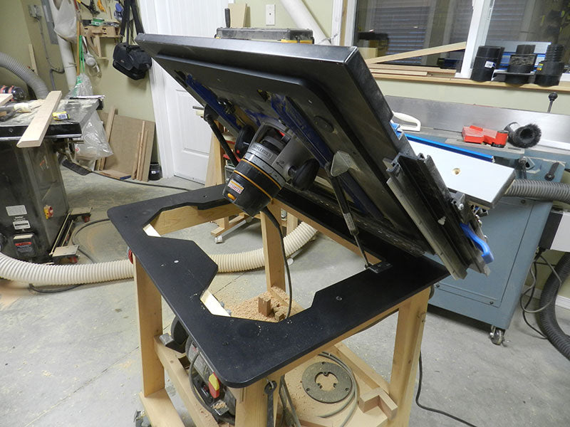 Table mounted router used with Dowelmax router lift in open position to provide access for router bit changes, bit height adjustments and cleaning