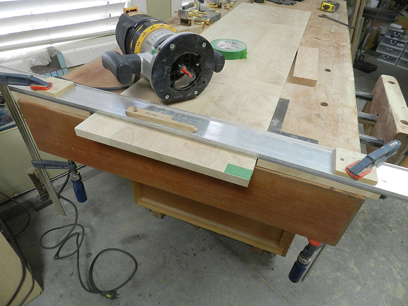 Hand held router used with fence to trim the edge of the entryway table top assembly main section
